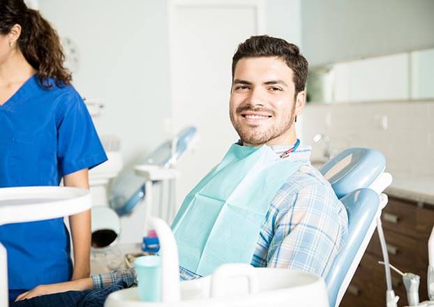 smiling man sitting in a dental chair