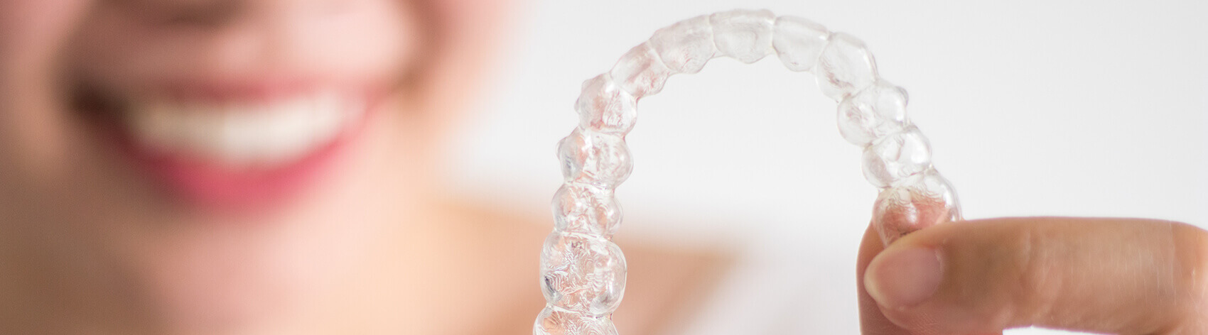 closeup of a person holding up their clear aligner